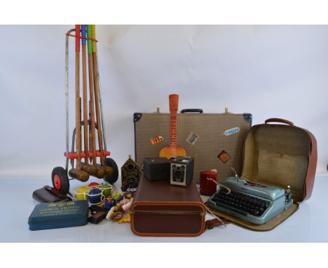 A mixed lot of toys and collectables, including a vintage croquet set, Imperial typewriter, two box cameras, Hong Kong water 