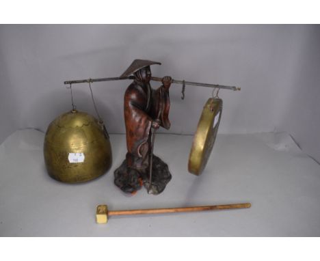 A 19th century spelter figure of a China man holding dinner gong and bell