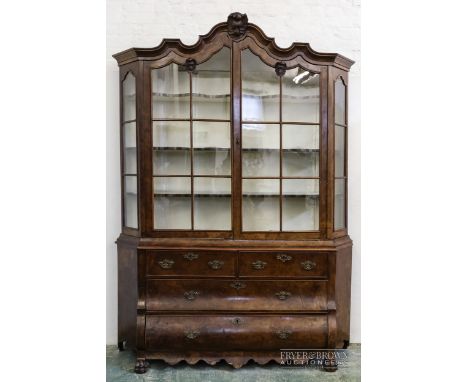 A Dutch burr walnut Delftware or china cabinet, the moulded cornice with rococo shell detail, a pair of glazed doors and side