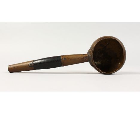 AN EASTERN BRASS AND HARDWOOD LADLE. 11ins long.
