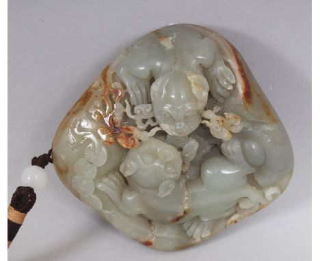 A CHINESE CELADON JADE BOULDER, decorated in relief with two Buddhistic lions and lingzhi, the stone with russet inclusions, 