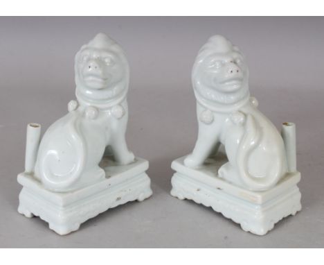 AN UNUSUAL PAIR OF CHINESE BLANC-DE-CHINE PORCELAIN JOSS STICK HOLDERS, each modelled in the form of a lion seated on a recta