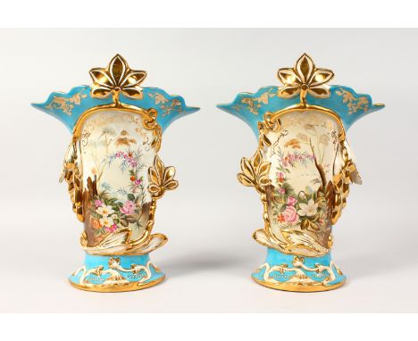 A PAIR OF SEVRES STYLE VASES, blue ground, decorated with a panel of flowers. 14ins high.