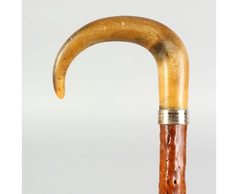 A RHINO HORN HANDLED WALKING STICK, with metal collar.