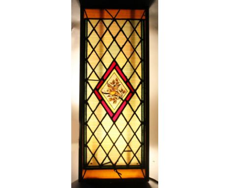 A 20TH CENTURY STAINED GLASS WINDOW, the central lozenge shape panel painted with a bird on a branch, mounted in a frame. 3ft