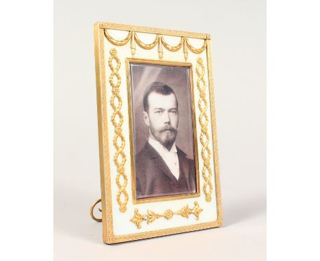A GOOD RUSSIAN SILVER GILT AND ENAMEL PHOTOGRAPH FRAME, the border applied with swags, laurel wreaths and flower head design.