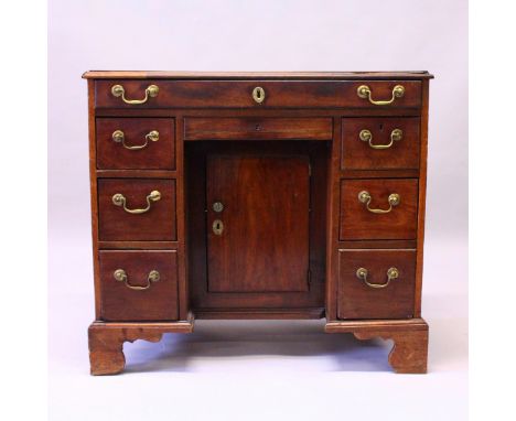 A GEORGE III MAHOGANY KNEEHOLE DESK, with a frieze drawer, small central drawer above a cupboard door, flanked by three drawe