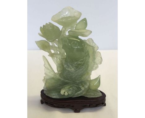A jade carving of a carp and pond lilies, 21.5cm tall (exc wooden base)