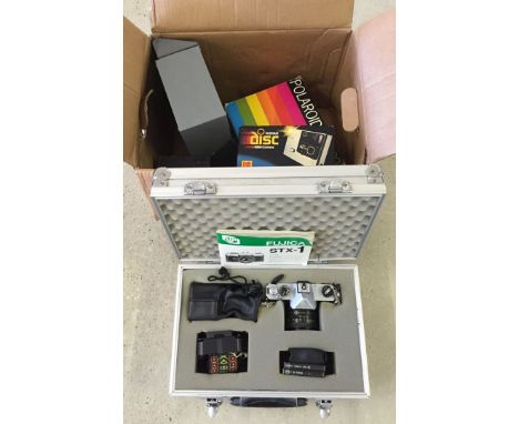 A cased Fujica STX-1 camera complete with telephoto lense together with Kodak Disc and Polaroid 320 cameras and accessories.