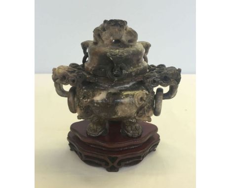 A soapstone 3 footed lidded incense urn on carved wooden base.