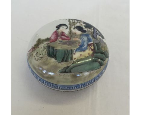 A small round ceramic trinket pot. Hand painted with Chinese ladies playing a game. Approx 9cm diameter.