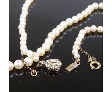 A graduated single standard long strand pearl necklace, on unmarked gold diamond set flowerhead clasp, clasp diameter 9.4mm, 
