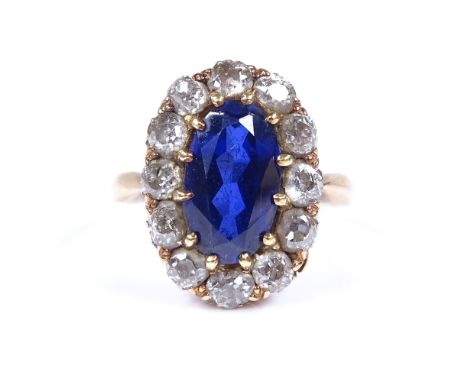 An unmarked gold large sapphire and diamond cluster ring, sapphire measures 11.5mm x 6.74mm x 4.2mm, setting height 17.6mm, s