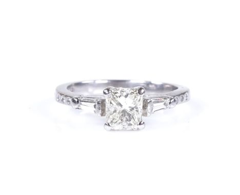 An 18ct white gold 0.65ct emerald-cut solitaire diamond ring, with tapered baguette-cut diamond shoulders and round-cut diamo