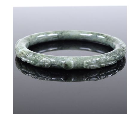 An Oriental carved nephrite bangle, internal diameter 64mm, 41.9g 