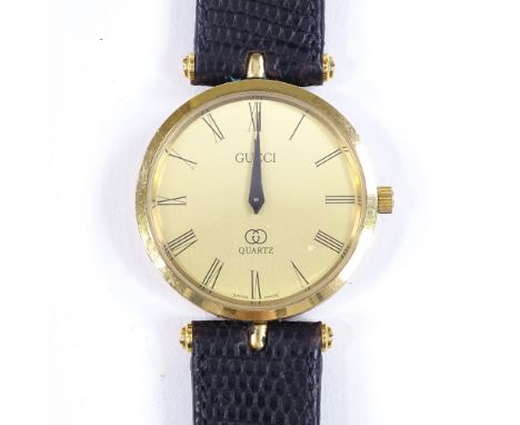 A Gucci Quartz wristwatch, gold plated case, champagne dial with ribbed black enamel case and monogram caseback, case width 3