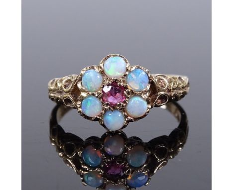 A 9ct gold opal and ruby cluster flowerhead ring, pierced and engraved shoulders, setting height 10mm, size N, 4.7g 