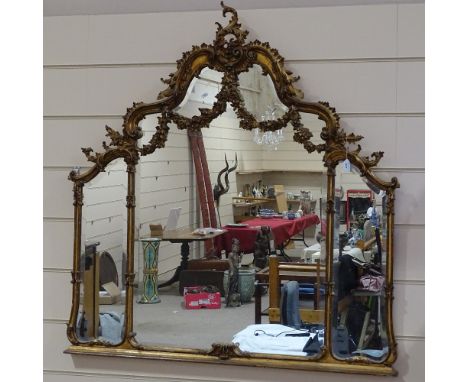 An ornate gilt-gesso framed triple glass over-mantel mirror, probably early 20th century, with bevel glass panels and acanthu