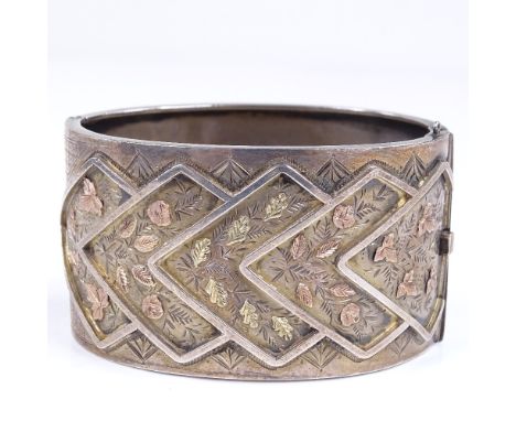 A Victorian wide silver hinged bangle, with applied 2-tone gold floral decoration, by Michael Joseph Goldsmith, hallmarks Bir