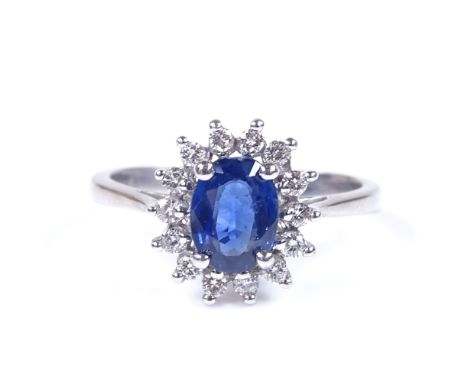 An 18ct white gold sapphire and diamond cluster ring, oval-cut sapphire approx 1.1ct, setting height 12.7mm, size Q, 5.1g 