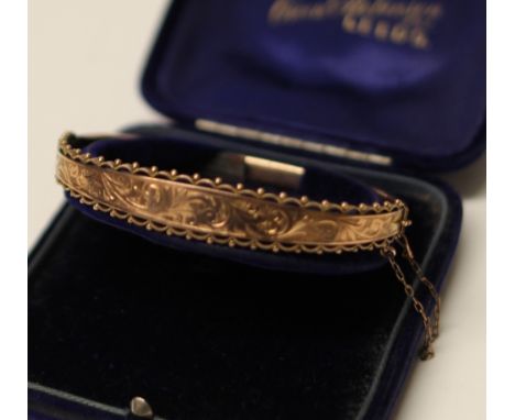 A 9CT GOLD ENGRAVED BANGLE  8.3G DIAMETER 7 CM