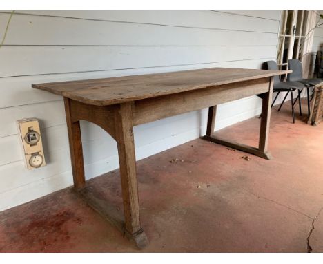 An Arts and crafts weathered light oak Cotswolds style dining table, the top of three planks on slightly splayed legs, joined