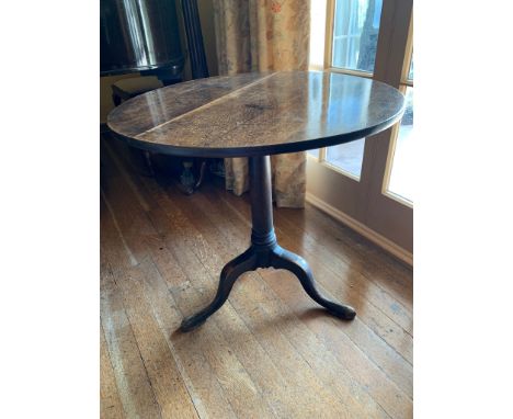 A George III oak tripod table, the ring turned stem on downswept cabriole legs with pad feet. (Dimensions: Height 71cm, diame