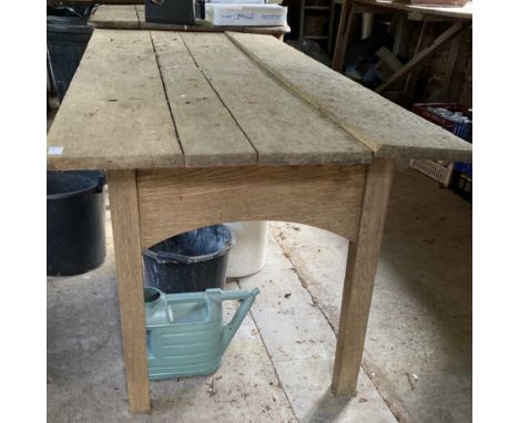 An Arts and crafts weathered light oak Cotswolds style dining table, the top of three planks on slightly splayed legs, joined