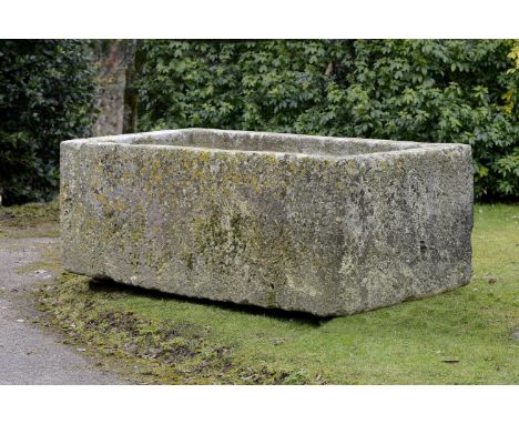 A large rectangular carved stone trough  64cm.; 25ins high by 183cm.; 72ins long by 92cm.; 36ins deep