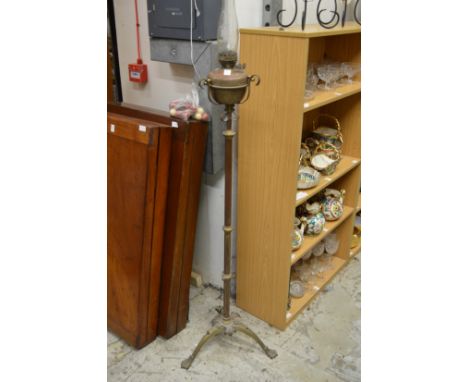 An adjustable floor standing oil lamp.