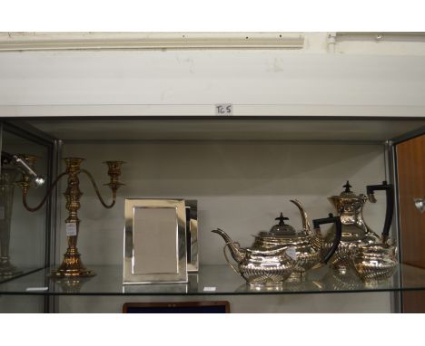 A plated four-piece tea service, a pair of picture frames and a candelabra.