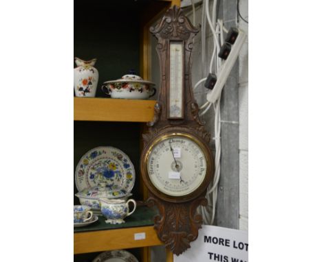 An oak cased barometer and thermometer.
