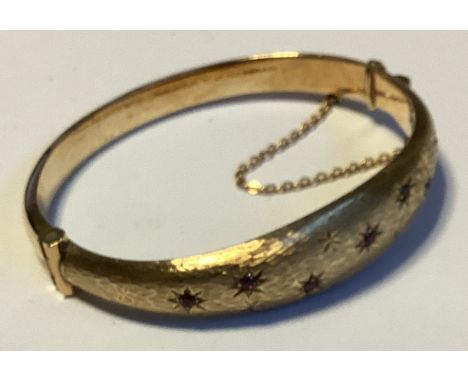 A small 9 carat hinged bangle. Approx. 8 grams. Est. £100 - £150.