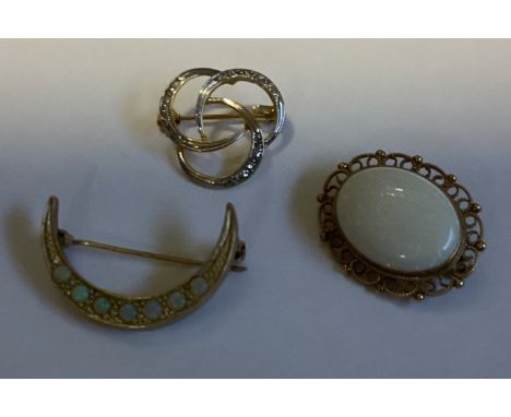 A 9 carat opal mounted brooch together with two other brooches. Approx. 100 grams. Est. £60 - £80.