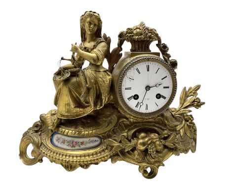 French-Gilt-metal mantle clock c1870, with a seated figure of a lady holding a pair of scales, on a scroll base with a porcel