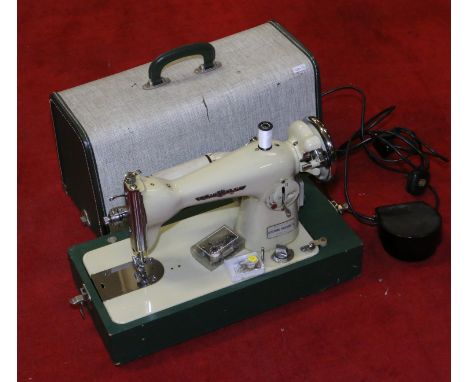 A cased vintage electric Sovereign Deluxe sewing machine.