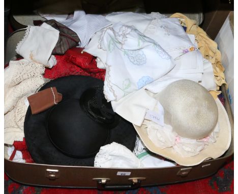 A vintage suitcase containing ladies hand bags, hats and materials.