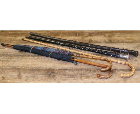 A collection of walking sticks and a umbrella to include sterling silver handled cane, bamboo etc. Condition Report. To be us