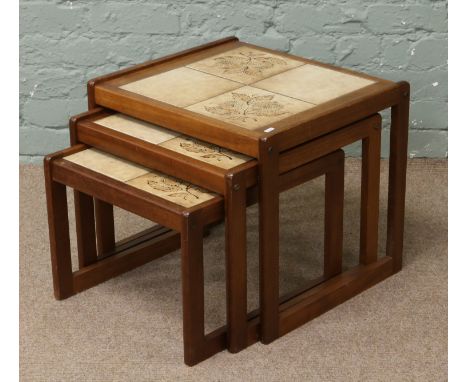 A nest of three teak, tile top occasional tables.