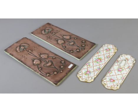 A pair of Art Nouveau copper finger plates, along with two ceramic examples. Copper 33cm x 13.5cm and mounted on boards.