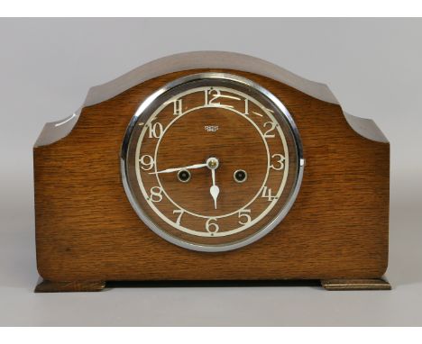 A c1930s oak cased mantel clock by Smiths with Arabic numeral dial enclosing a twin train movement on a coiled gong.
