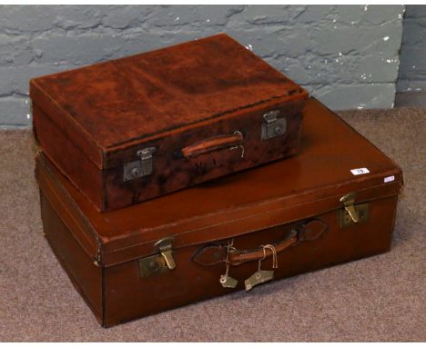 Two vintage leather suitcases.