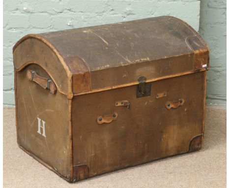 A leather and canvas dome topped travel trunk by James Shoolbred & Co. of London.
