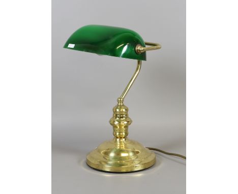 A brass based adjustable reading lamp with green glass shade.