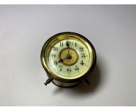 A SMALL VINTAGE BRASS CAR CLOCK WITH ENAMEL DIAL 