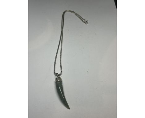 A MARKED SILVER NECKLACE WITH A JADE TOOTH PENDANT 