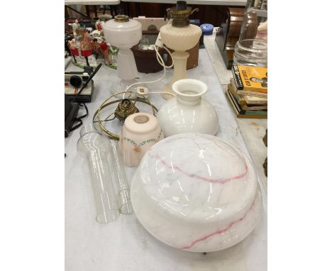 A QUANTITY OF VINTAGE LAMPS AND SHADES TO INLUDE AN OIL LAMP CONVERTED TO ELECTRICITY, OIL LAMP CHIMNEYS, GLASS SHADES, ETC 
