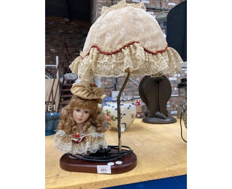 A TABLE LAMP WITH ON A WOODEN BASE WITH CERAMIC LADY'S HEAD DECORATION 