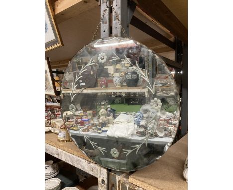 A VINTAGE ROUND FRAMELESS MIRROR WITH BEVELLED EDGING AND FLORAL DECOR 