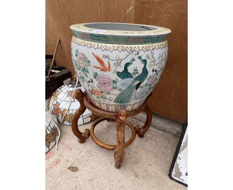 A LARGE CERAMIC PLANTER WITH ORIENTAL MARKINGS TO BASE AND A WOODEN TRIPOD STAND 